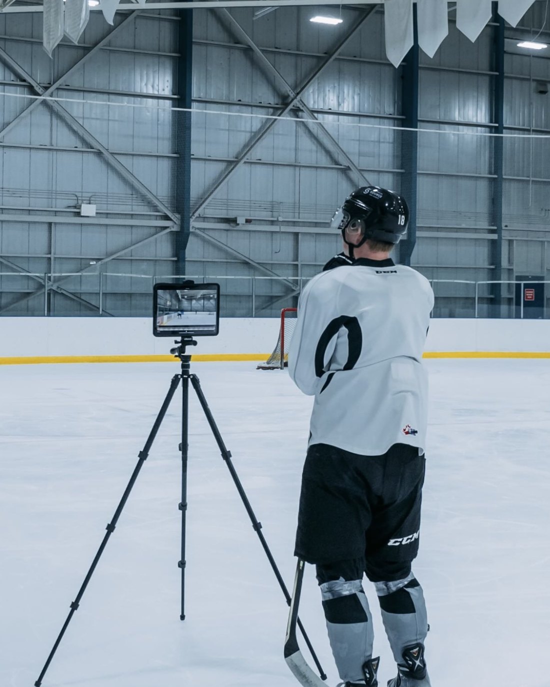 A NEXTERA athlete watching his shift back on a tablet during an on-ice session